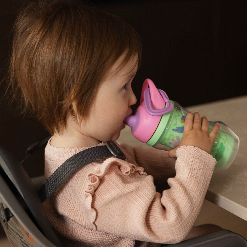 A young child holding the Insulated Sipper cup by Nuby.