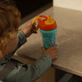 A young child holding the Insulated Sipper cup by Nuby.