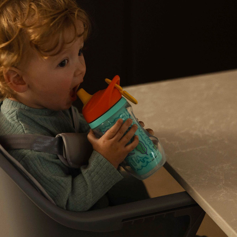 A young child holding the Insulated Sipper cup by Nuby.