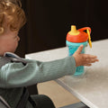 A young child holding the Insulated Sipper cup by Nuby.
