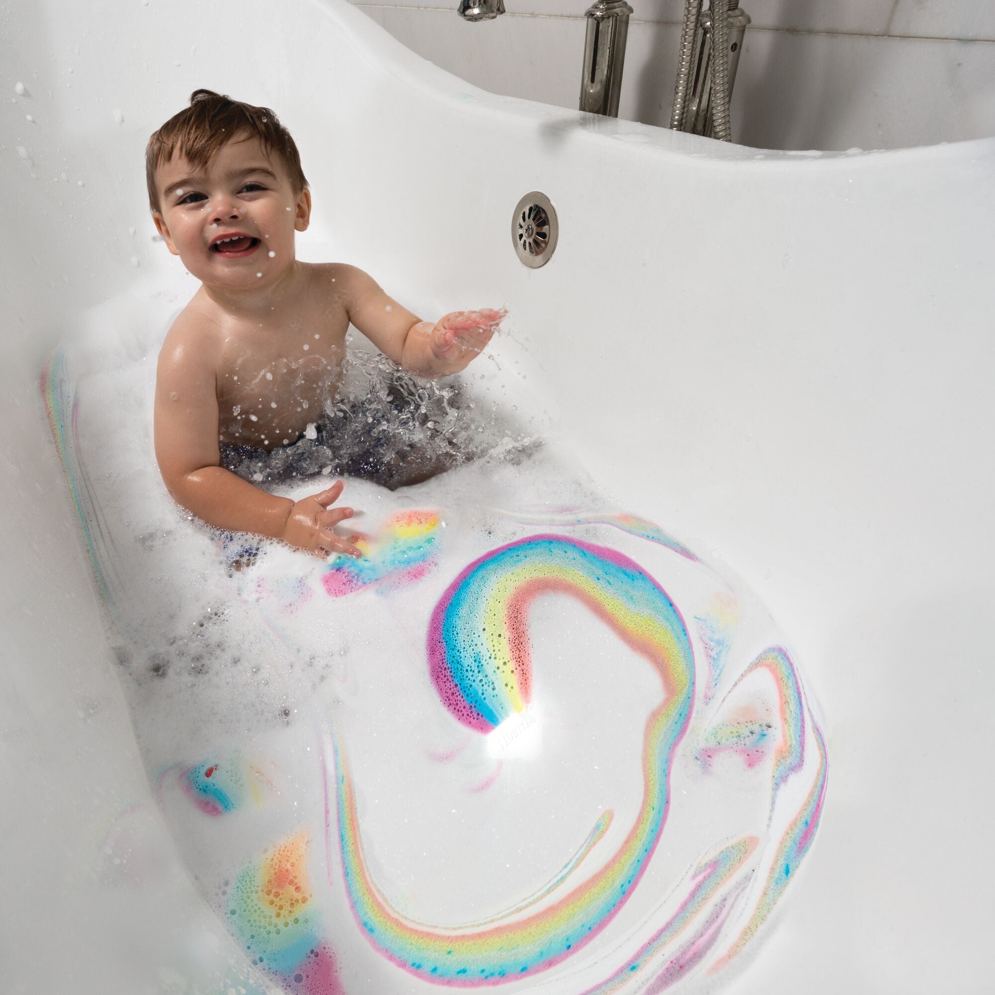 A young boy interacting with their Rainbow Bath Fizzies by Nuby.