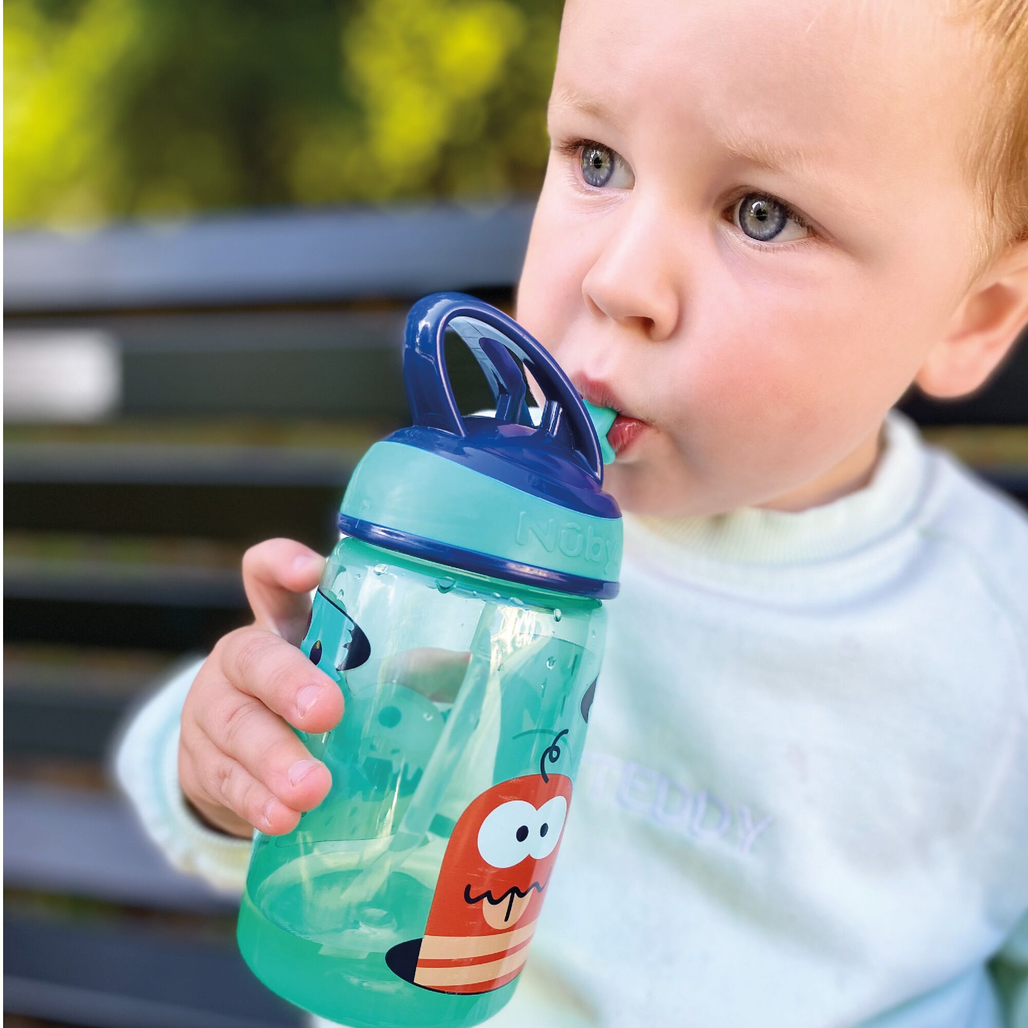 A young boy drinking from the Mighty Swig Monsters sippy cup from Nuby.