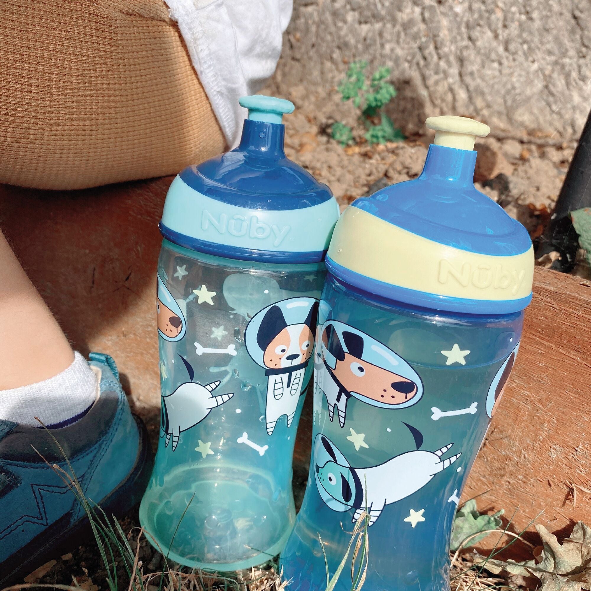 The pair of Dog decorated Super Straw ippy cups by Nuby. They come in two colours shown in blue, green and yellow between them.