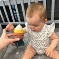 A baby playing with the Rocket Stacker Toy by Nuby.