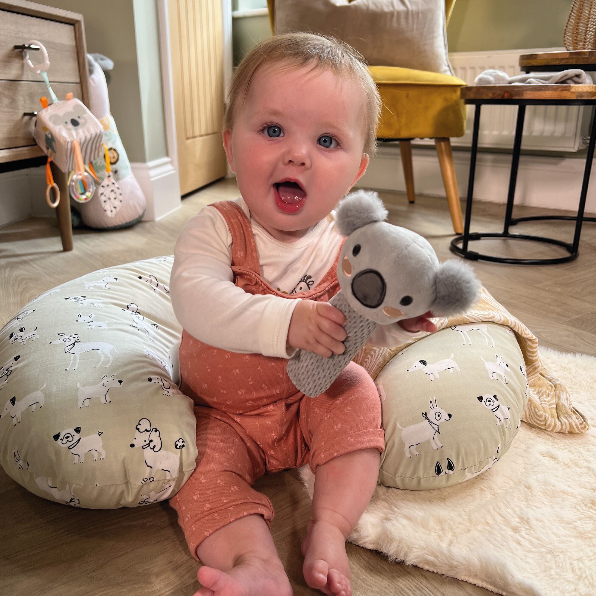 A baby holding the Koala bear from the Animal Adventures gift set by Nuby.