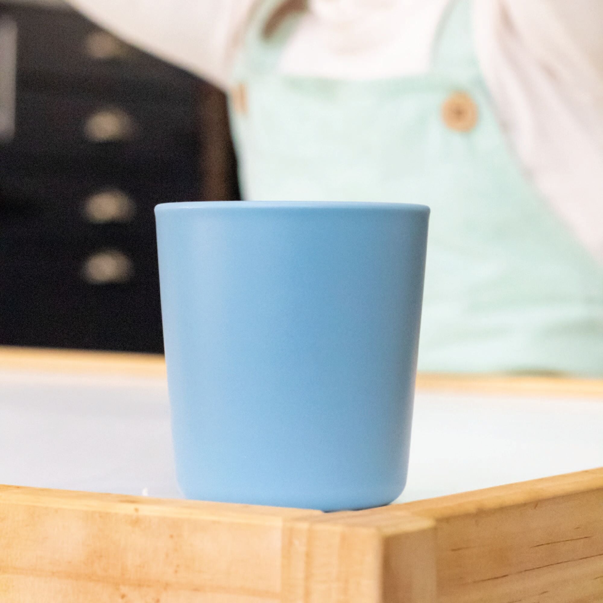 A tumbler in blue sat on a kitchen table created by Nuby.