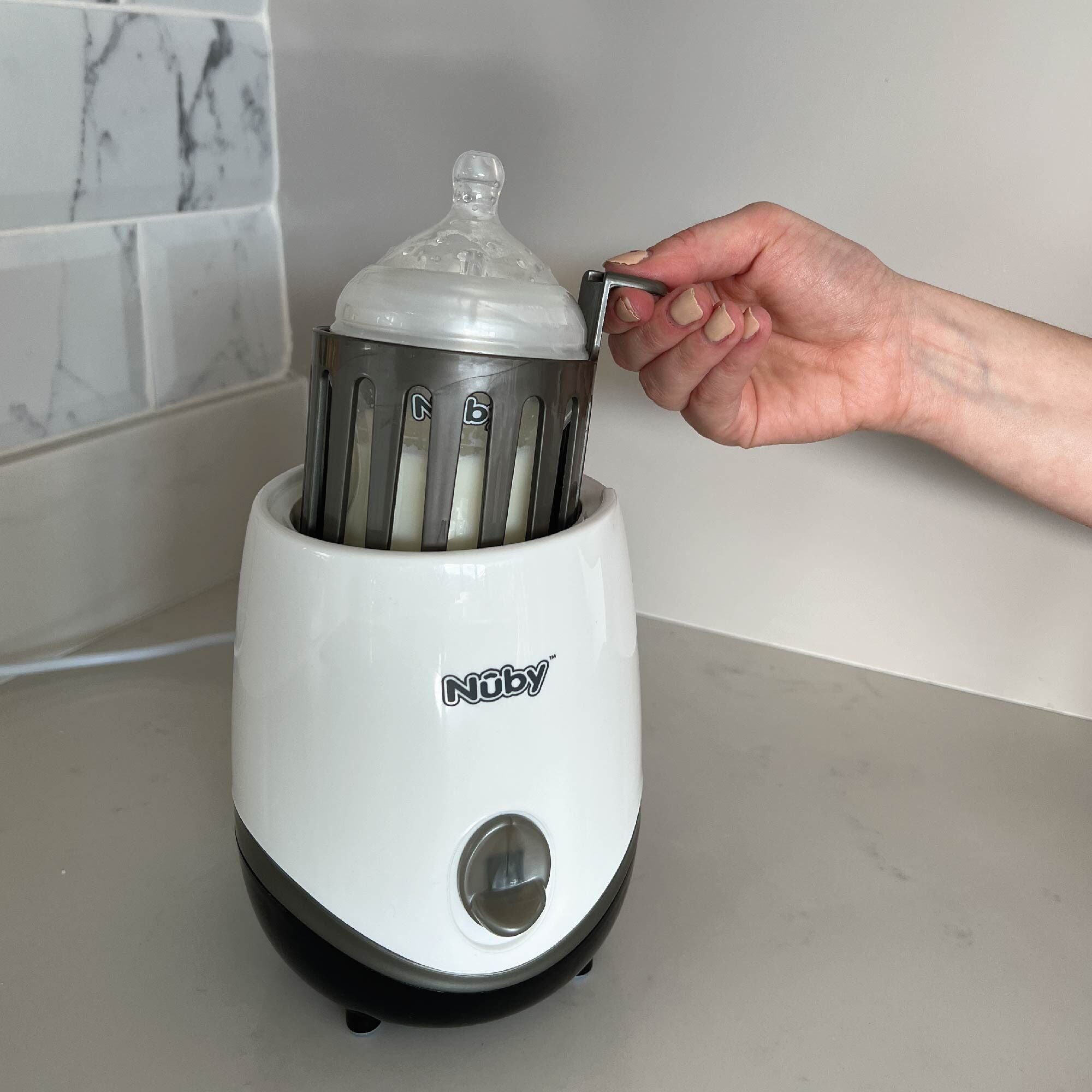 The bottle food warmer on a desktop by Nuby.