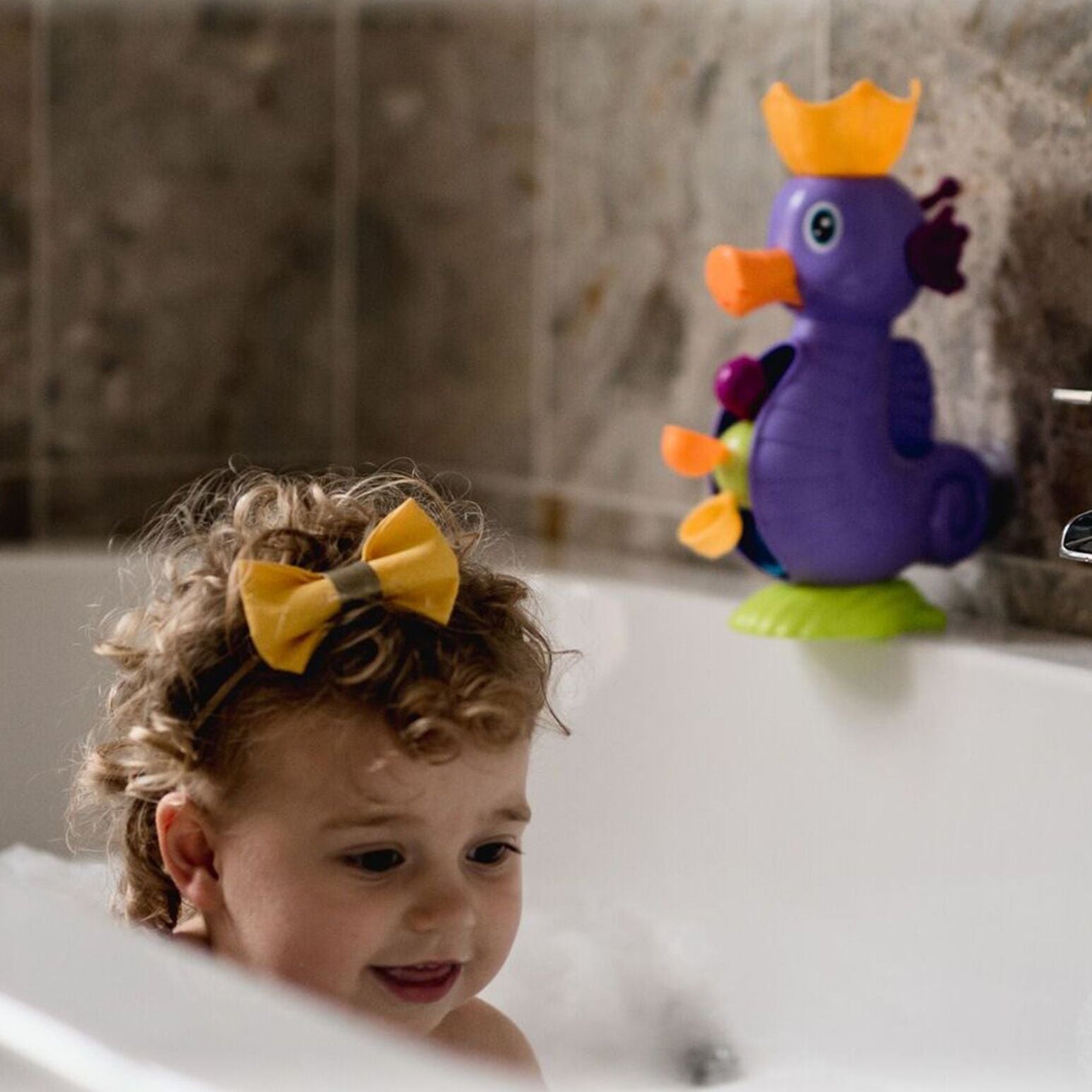 The SeaHorse bath toy by Nuby sitting on top of a bath.