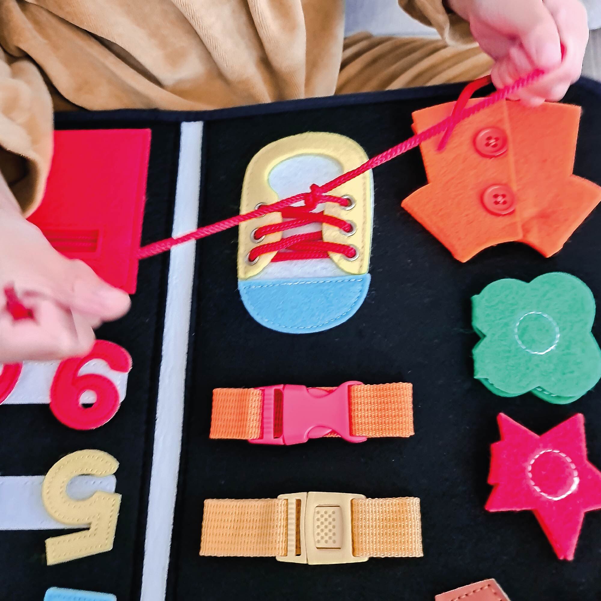 Shoelaces being tied as part of the My Busy Book sold by Nuby.