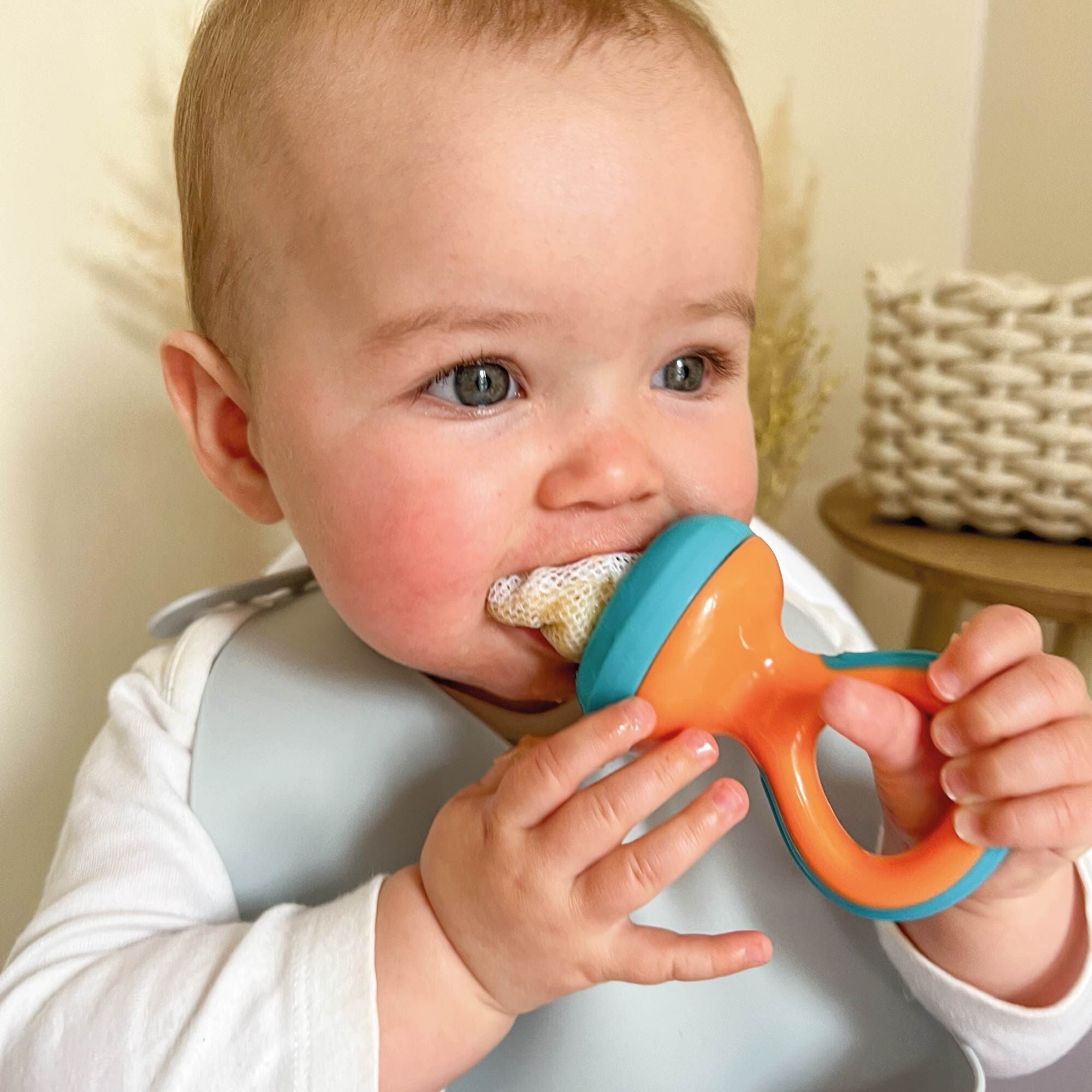 A baby eating from the Nuby Nibbler.