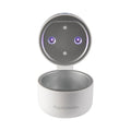 A white, round RapidSterilise UV Soother Steriliser with its lid open reveals two small purple LED lights and a metallic circular interior, designed to sterilise small items.