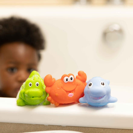 A baby looking at the bath squirter toys from Nuby.