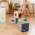 The Little Learner Cubes by Nuby laid out on a living room floor.