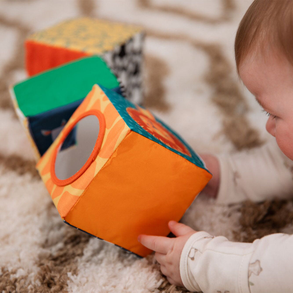 A young child playing with Nuby's Little Learner Cubes, this includes a Lion.