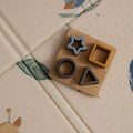 The Nuby Foldable Play Mat, Safari, features textured giraffe and blue snake designs with a wooden sorting toy that includes star, square, circle, and triangle shapes.