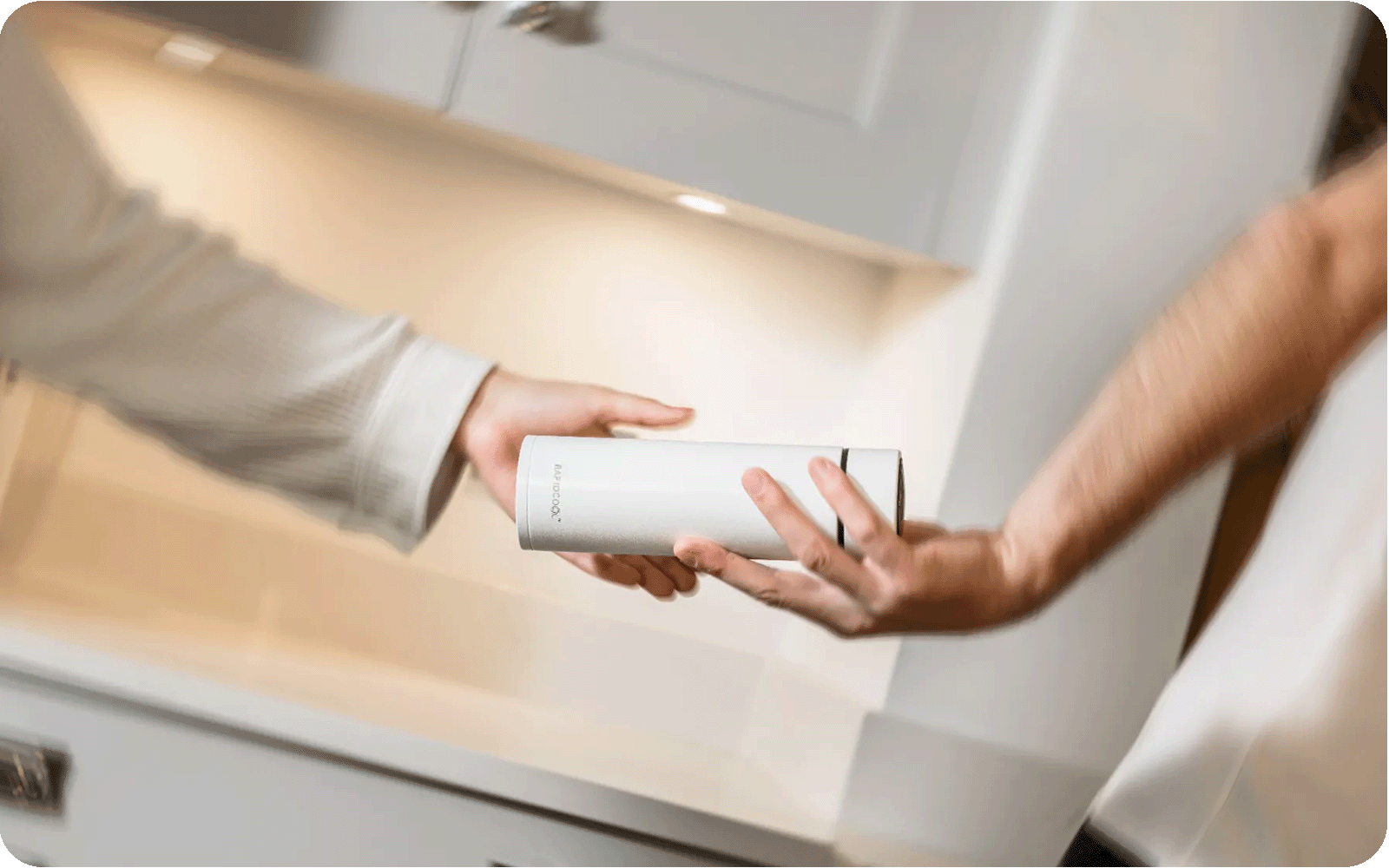 A mother passing a father a RapidCool while in the kitchen.