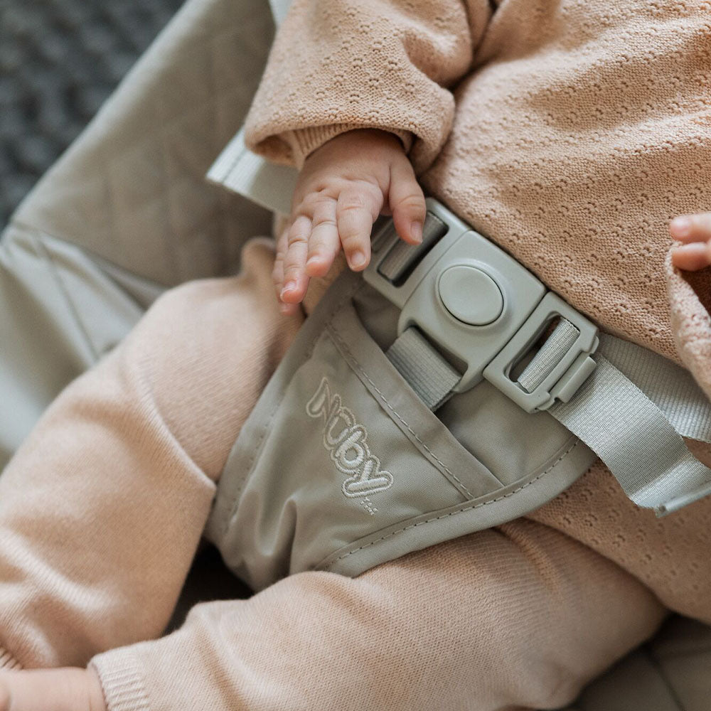 A baby relaxed in their Nuby Musical Moves Bouncer Chair.