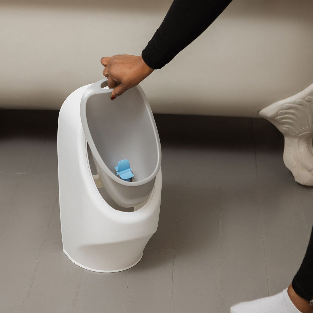A My Real Urinal section being lifted from its' space. This is sat on a bathroom floor next to a bath.
