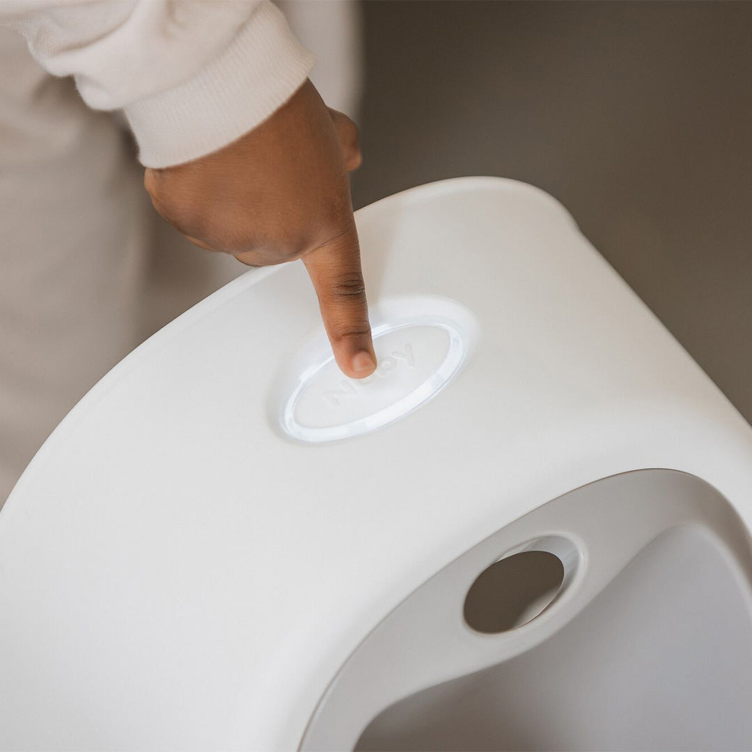 The Nuby button being pressed by a child's finger.