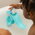 A child enjoys bath time with the Nuby Splash N Slide Penguin Bath Toy, sliding the blue penguin down a light blue plastic slide attached to the tub and enhancing motor skills through playful water fun.