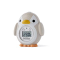 Penguin Bath & Room Thermometer Thermometer Nuby, sat on a white table at an angle. The thermometer has a yellow beak and orange feet.