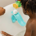 The Penguin bath slide toy from Nuby, with a polar bear at the top of the slide being played with by a young child in a bath.
