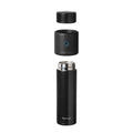A black insulated travel mug with its lid and a Nuby UK RapidSterilise Baby Bottle Maker Steriliser component shown floating above, all separated and vertically aligned on a white background.