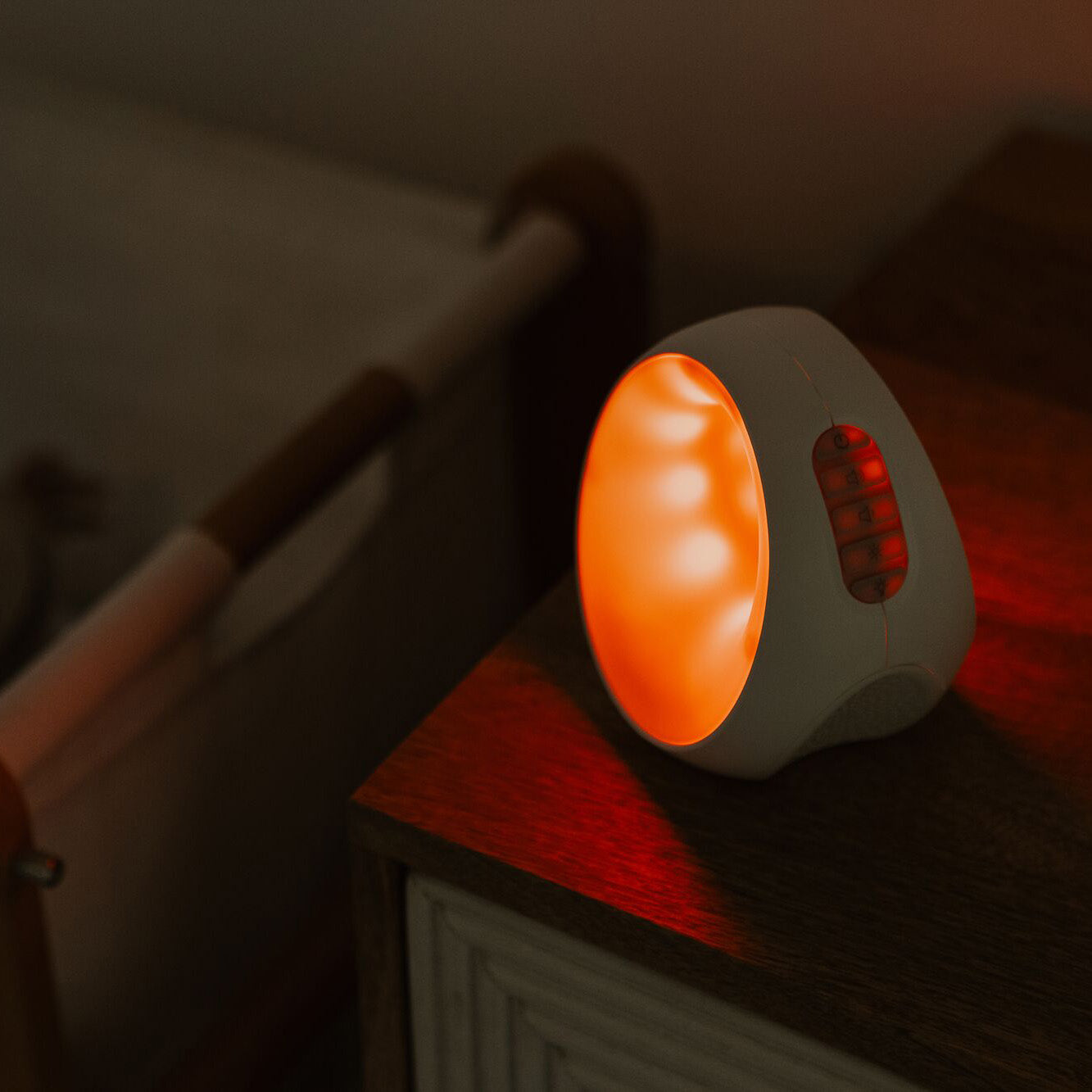 The sleep and sound by Nuby emitting an orange colour in a bedroom.