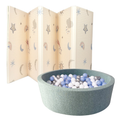 The Nuby UK Play and Explore Bundle features a soft, foldable baby play mat with star, cloud, and rainbow designs behind a round green jersey ball pit filled with blue, white, and silver plastic balls.