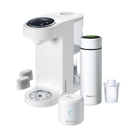 The Nuby UK Formula Making Set, featuring a white countertop appliance with digital display, portable bottle steriliser, cylindrical bottle, filter, and two gray pods, is shown arranged on a white background.