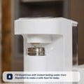 A close-up of a white water dispenser with a bottle under the spout. Text overlay: Use Nuby UKs Formula Making and Sterilising Bundle for instant boiling water—ideal for formula feeding essentials and safe baby feeds.