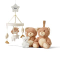 The Biscuit Bear Bedtime Bundle features a baby mobile with plush stars and a bear, two brown teddy bears, and a white bear-shaped nightlight, all displayed on a white background.