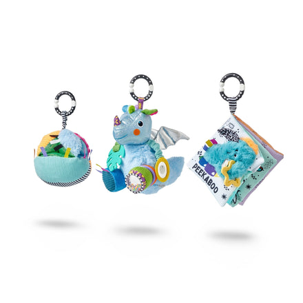The Things with Wings Pram Toy Bundle includes a soft ball with tags, a plush dragon with wings and textures, and a peekaboo fabric book. Each sensory toy has a striped hanging ring—ideal as a newborn gift.