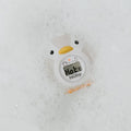 The Nuby UK Newborn Bath Support & Thermometer, shaped like a white duck, floats in soapy bath water and displays Hot on its digital screen.