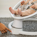 Parent adjusting a setting on the base of the remote control baby swing