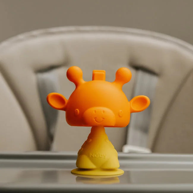 The Nuby Bobble Highchair & Teething Toy, a yellow and orange silicone giraffe with a smiley face, sits on a highchair tray. Perfect for soothing little gums, this fun teether is ideal for your baby’s comfort.