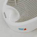 Close-up of a white Nuby UK Newborn Bath Support & Thermometer with a gray perforated surface. WATER LEVEL and a red arrow show the recommended fill height as water is poured into the bath.