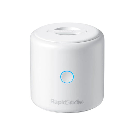 A small, white, cylindrical device labeled RapidSterilise Baby Bottle Maker Steriliser by Nuby UK features a circular blue-lit front button and is shown on a plain white background. It sterilises baby bottles using UV technology.