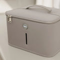 A light gray, rectangular storage case with handle and double zippers, featuring a small oval Nuby UK logo—ideal for carrying your RapidCool™ Bottle Maker and UV Steriliser Bundle. Includes a narrow vertical front slot and rests on a smooth surface.