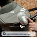 A hand uses the Nuby UK Jitterbug Pram Rocker attached to a stroller handle. The device glows, with a caption noting its 3 vibration levels and 7 color lights designed to help babies sleep.