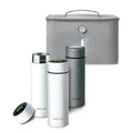 Three stylish bottles—two white, one gray—with black lids and Nuby UK branding are displayed before a gray insulated case. Perfect for the Nuby UK RapidCool™ Kit and UV Steriliser Bundle for convenient baby feeding on the go.